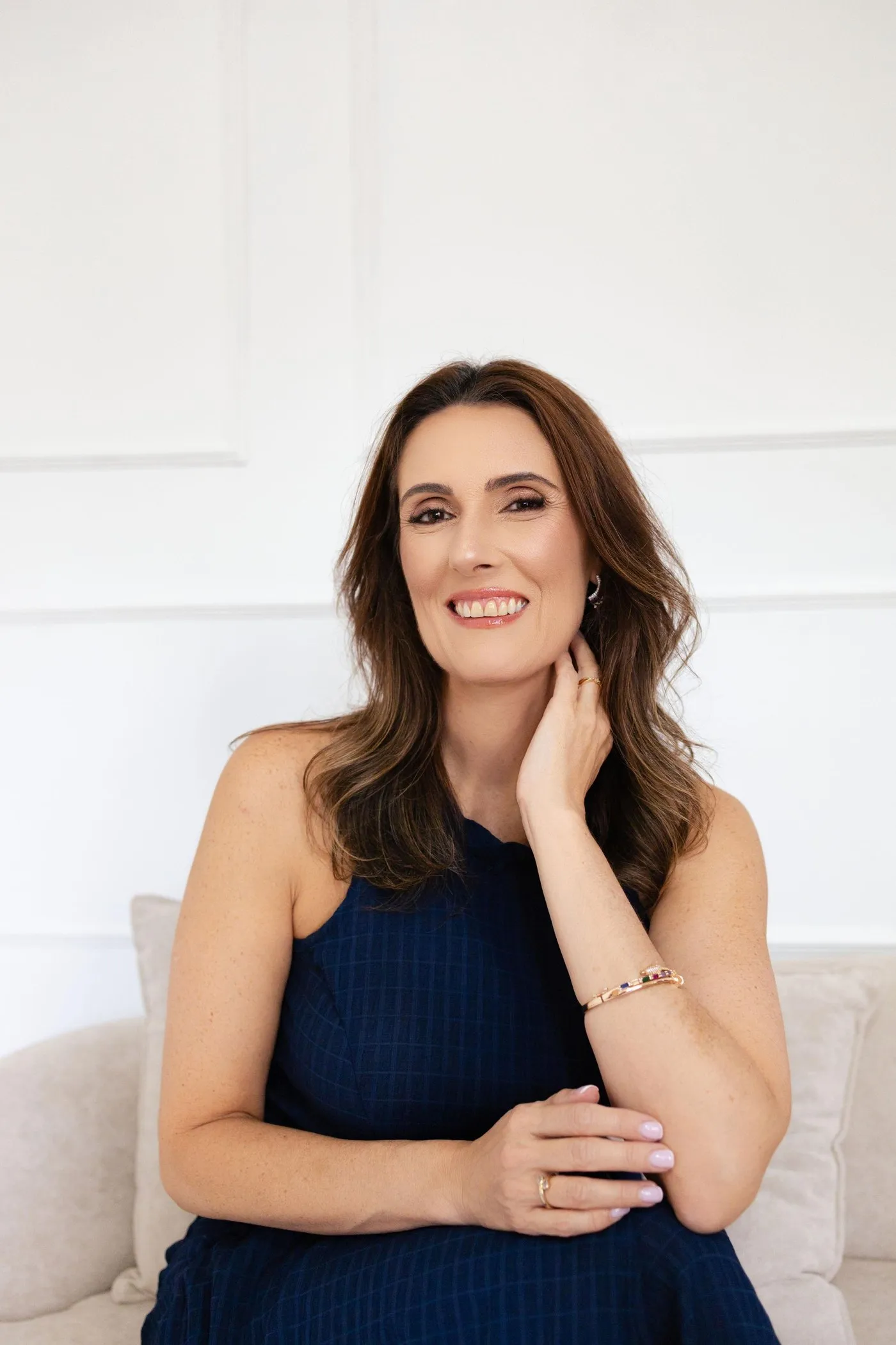 Dra. Jussara Brito sentada, sorrindo, em ambiente claro
